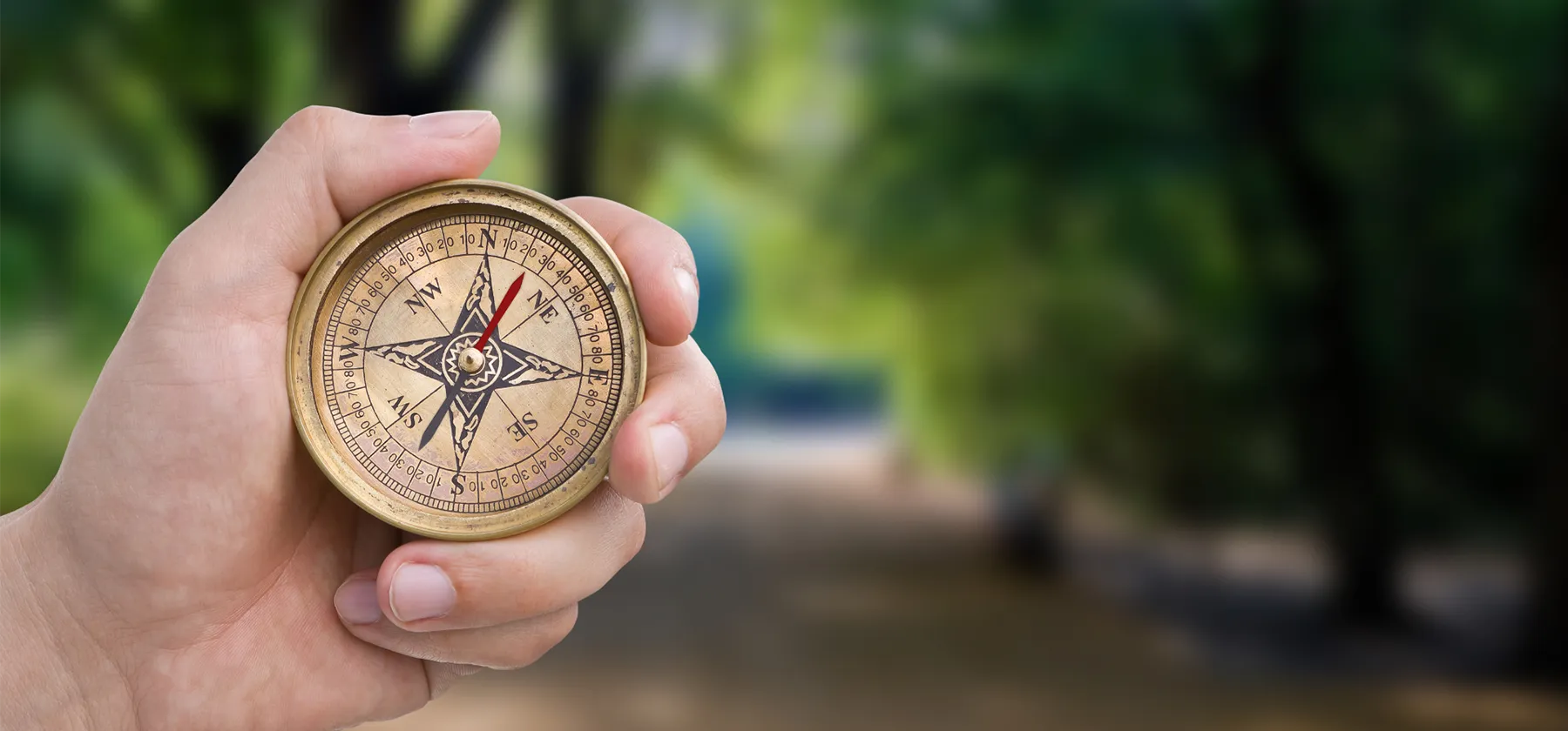 A compass held outdoors, representing values as a steady direction rather than a finish line
